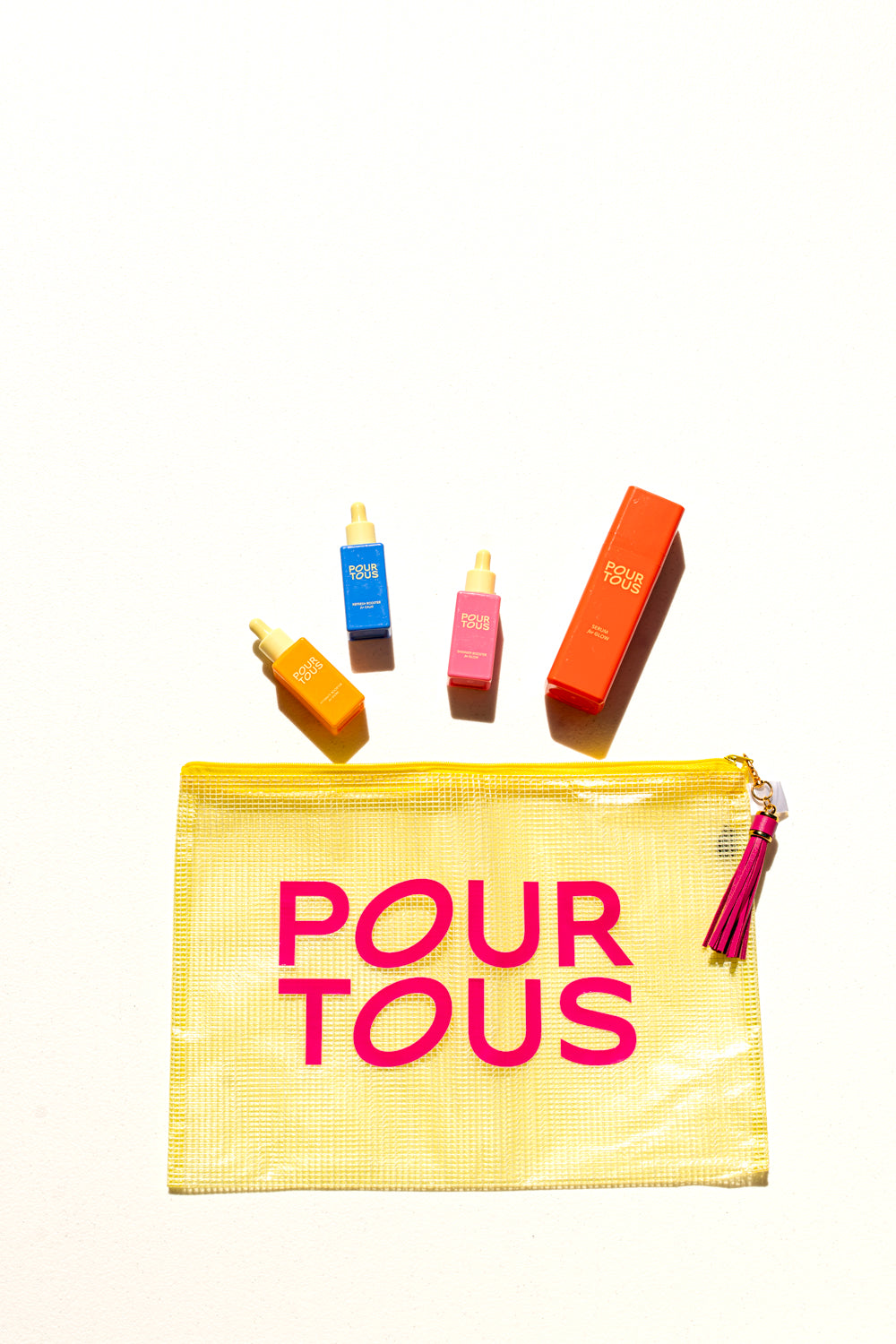 colorful skincare bottles and pouch with 'pour tous' text