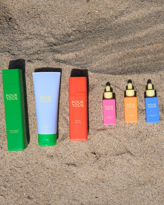 Pour Tous skincare products on sand