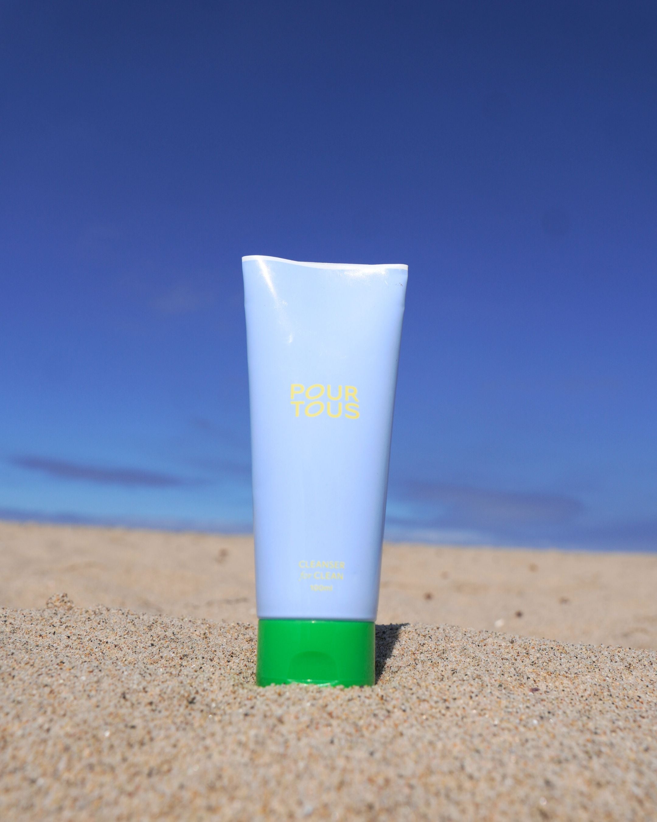 skincare tube on sand under blue sky