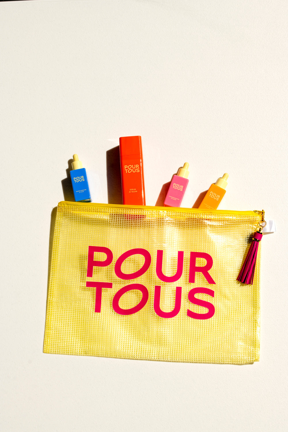 "yellow bag with skincare bottles pour tous"