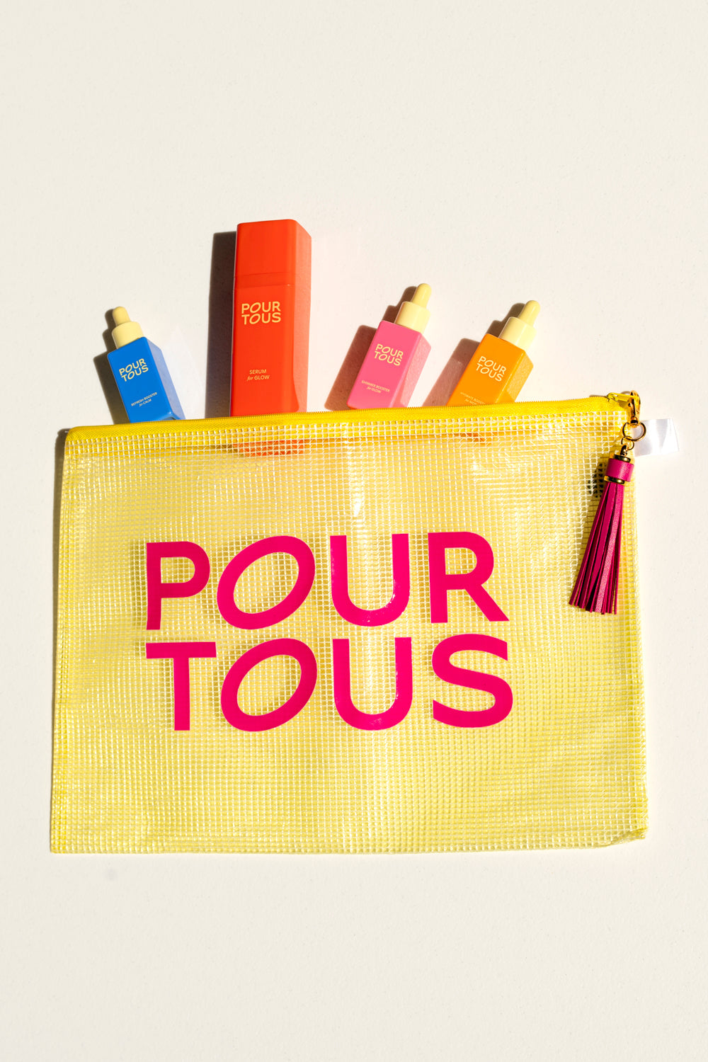 Yellow pouch with Pour Tous skincare serums.