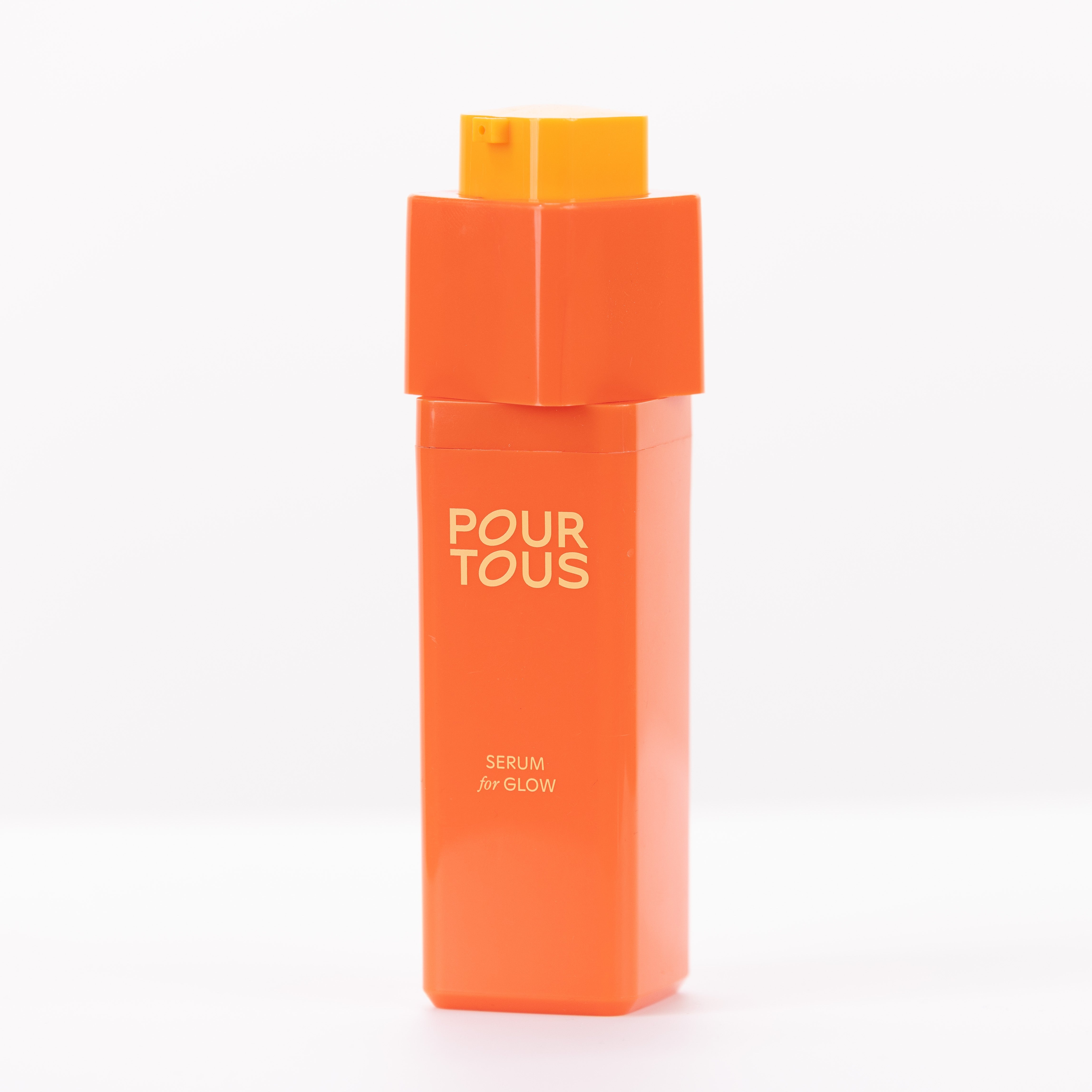 Orange skincare serum bottle with text "Pour Tous" and "Serum for Glow".