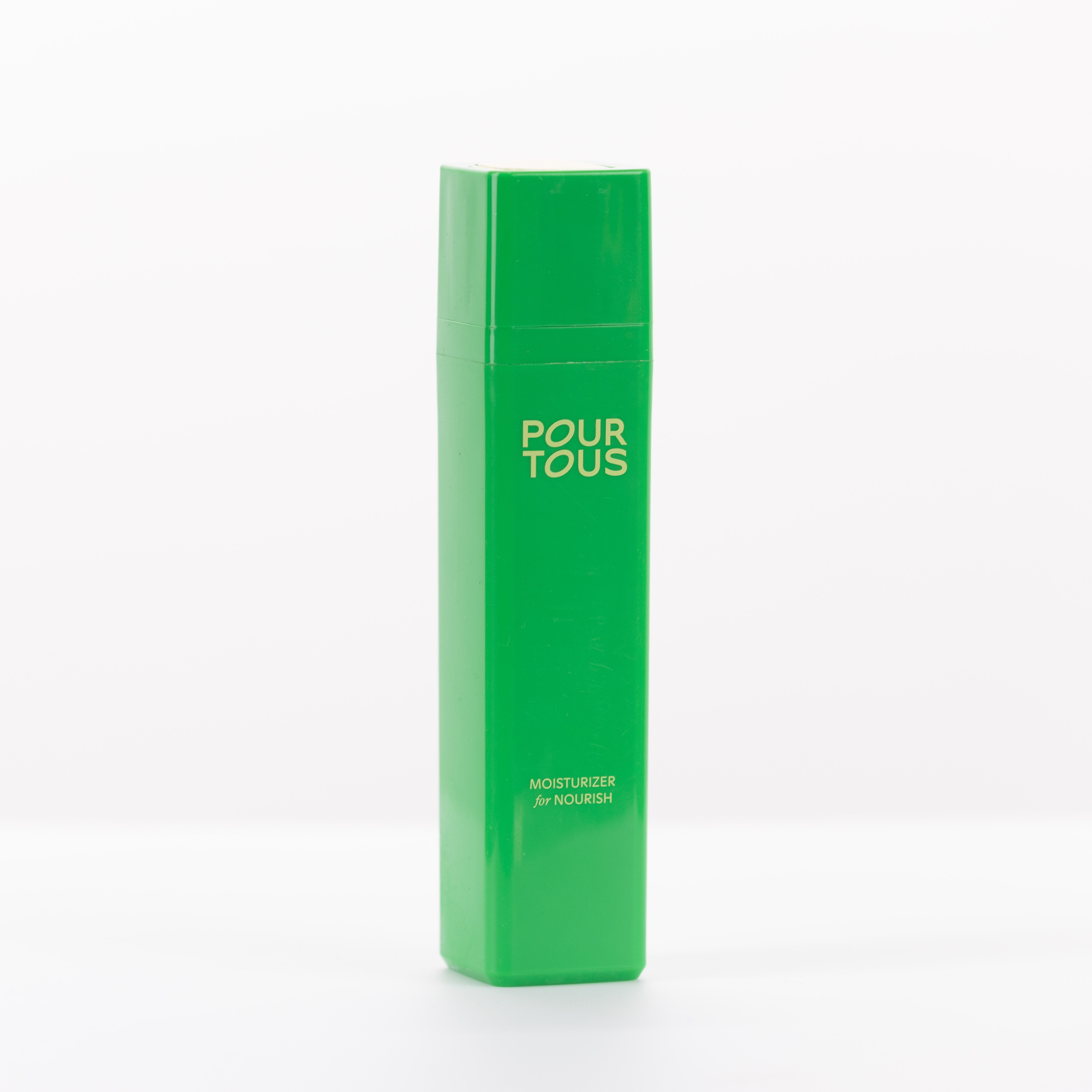 Green Pour Tous moisturizer bottle on white background.