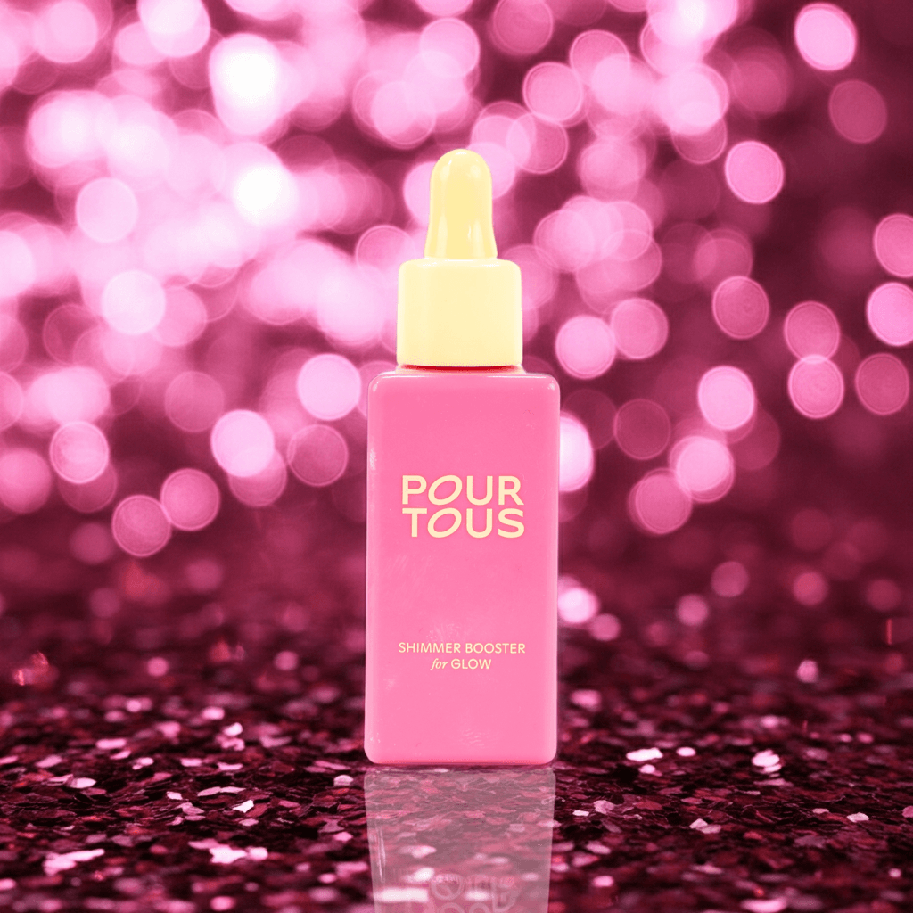 Pink serum bottle with dropper on glitter background.